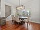 Bright dining room boasts hardwood floors, stone accent wall, modern chandelier, and large windows at 3535 Lake Sarah Dr, Orlando, FL 32804