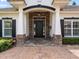 Inviting entryway featuring a stone facade, stately columns, and a well-lit, covered porch at 3535 Lake Sarah Dr, Orlando, FL 32804