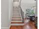Staircase leads to the upper level, featuring hardwood steps and decorative wrought iron railings at 3535 Lake Sarah Dr, Orlando, FL 32804