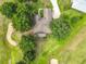 Aerial view of a home with a screened-in pool, surrounded by mature trees and lush greenery at 36730 Oconee Ave, Eustis, FL 32736