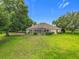 Expansive backyard with a screened patio, backing onto a scenic golf course and mature trees at 36730 Oconee Ave, Eustis, FL 32736
