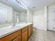 Bright bathroom featuring a double sink vanity, large mirror, and a shower-tub combination with tiled walls at 36730 Oconee Ave, Eustis, FL 32736