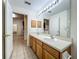 Well-lit bathroom with a double sink vanity, a large mirror, and views into adjacent rooms at 36730 Oconee Ave, Eustis, FL 32736