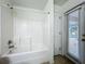 Bathroom featuring a tub/shower combo and an exterior door with blinds for light control at 36730 Oconee Ave, Eustis, FL 32736