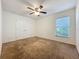 Spacious bedroom featuring a ceiling fan, double closet, and a window providing natural light at 36730 Oconee Ave, Eustis, FL 32736