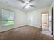 Bedroom with a ceiling fan, closet, and a window offering natural light, showing some wear and tear at 36730 Oconee Ave, Eustis, FL 32736