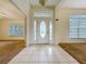 Tiled foyer with sidelight door and transom window, leading to a carpeted living space at 36730 Oconee Ave, Eustis, FL 32736