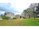 Charming single-story home with a well-manicured lawn, mature trees, and tasteful landscaping at 36730 Oconee Ave, Eustis, FL 32736