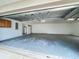Open three-car garage space with visible mechanical components and room for parking, showing floor wear at 36730 Oconee Ave, Eustis, FL 32736