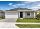 Inviting single-story home with manicured lawn, a paved driveway, and a 2-car garage at 3756 Watercliff Cir, Grand Island, FL 32735