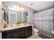 Bathroom featuring double sinks, modern vanity, large mirror, shower with tub and decorative shower curtain at 3943 Crawley Down Loop, Sanford, FL 32773