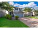 Charming two-story home featuring a well-manicured lawn, brick driveway, and inviting entrance framed by lush landscaping at 3943 Crawley Down Loop, Sanford, FL 32773