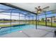 Inviting screened-in pool with clear water, complemented by a beautiful lake view and lush greenery at 3943 Crawley Down Loop, Sanford, FL 32773