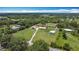 Lovely aerial view of a home with green lawn, mature trees and outbuildings at 4160 Packard Avenue, St Cloud, FL 34772