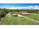 Aerial view of a well-maintained home on a sprawling green lawn with a long driveway at 4160 Packard Avenue, St Cloud, FL 34772