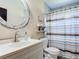 Bathroom featuring a patterned shower curtain, white vanity, and decorative mirror at 4160 Packard Avenue, St Cloud, FL 34772