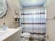 Cozy bathroom featuring a patterned shower curtain, white vanity, and decorative mirror at 4160 Packard Avenue, St Cloud, FL 34772