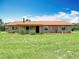 Charming brick home with a metal roof surrounded by lush green lawn at 4160 Packard Avenue, St Cloud, FL 34772