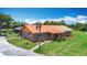 Beautiful brick home with a metal roof, mature landscaping, and charming lamppost at 4160 Packard Avenue, St Cloud, FL 34772