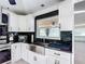 Modern kitchen with stainless steel appliances, including a farmhouse sink, set against a black backsplash at 4160 Packard Avenue, St Cloud, FL 34772