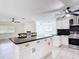 Open kitchen featuring an island with black countertops, white cabinets, and stainless steel appliances at 4160 Packard Avenue, St Cloud, FL 34772