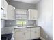 Contemporary kitchen with white cabinetry and stone-look counters at 4160 Packard Avenue, St Cloud, FL 34772