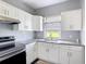 Modern kitchen with white cabinets, granite countertops, and stainless steel appliances at 4160 Packard Avenue, St Cloud, FL 34772