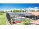 Relax by the in-ground pool under a screened enclosure, complemented by lush landscape and shade at 4160 Packard Avenue, St Cloud, FL 34772
