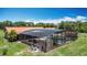 A screened in-ground pool is bordered with a deck and lush tropical landscaping in a backyard at 4160 Packard Avenue, St Cloud, FL 34772