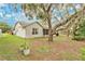 Property backyard features large trees, green lawn, and access to a screened in porch at 4865 Gorham Ave, Orlando, FL 32817