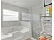 Bright bathroom with garden tub and separate shower featuring a glass door and tiled surround at 4865 Gorham Ave, Orlando, FL 32817