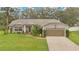 Charming single-story home with well-manicured lawn, mature trees, and welcoming front entrance, complete with a two-car garage at 4865 Gorham Ave, Orlando, FL 32817