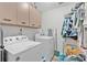Functional laundry room equipped with washer, dryer, and upper cabinets for storage at 4865 Gorham Ave, Orlando, FL 32817