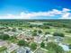 Neighborhood aerial view of suburban homes featuring lush green trees and picturesque lake views at 5125 Pine Needle Dr, Mascotte, FL 34753