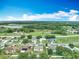Neighborhood aerial view of suburban homes with lush green trees and picturesque lake views at 5125 Pine Needle Dr, Mascotte, FL 34753