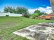 View of the home's backyard featuring grass and a weathered concrete patio at 5125 Pine Needle Dr, Mascotte, FL 34753