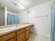 Standard bathroom featuring single sink vanity and large mirror with light fixture above at 5125 Pine Needle Dr, Mascotte, FL 34753