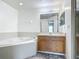 Bright bathroom featuring a large soaking tub, vanity with wood cabinets, and neutral color scheme at 5125 Pine Needle Dr, Mascotte, FL 34753