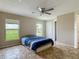 Bedroom with a ceiling fan, two windows, and a closet for ample storage at 5125 Pine Needle Dr, Mascotte, FL 34753