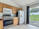 A modern kitchen featuring wood cabinets, stainless steel appliances, and backyard views at 5125 Pine Needle Dr, Mascotte, FL 34753