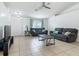 Open-concept living room featuring tile flooring, modern ceiling fan and plenty of natural light at 5125 Pine Needle Dr, Mascotte, FL 34753