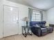 Cozy living room area featuring tile floors, a comfortable couch, and a view of the bright outdoors at 5125 Pine Needle Dr, Mascotte, FL 34753
