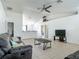 Inviting living room with tile flooring, ceiling fan, and vaulted ceilings showcasing neutral wall color at 5125 Pine Needle Dr, Mascotte, FL 34753