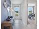 Bright entryway with tile flooring, complemented by modern decor, a glass-paneled front door, and a view of the office space at 5162 Masser Rd, St Cloud, FL 34772