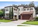 Stunning two-story stucco home featuring a three-car garage, tile roof, and beautifully landscaped front yard at 617 Canopy Estates Dr, Winter Garden, FL 34787