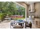 Outdoor patio with built in grill and a dining area, water feature and lush landscaping at 617 Canopy Estates Dr, Winter Garden, FL 34787