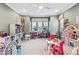 Bright playroom features built-in bookshelves, a ceiling fan, a large window, and lots of toys at 617 Canopy Estates Dr, Winter Garden, FL 34787