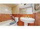 A bathroom with brown, red, and tan tiled walls and a standard toilet, sink, and tub at 624 American Heritage Pkwy, Orlando, FL 32809