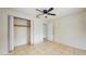 A bright bedroom is shown with tile floors, a ceiling fan, and a closet at 624 American Heritage Pkwy, Orlando, FL 32809