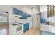 Cozy kitchen with blue cabinets, white appliances, and tile flooring at 624 American Heritage Pkwy, Orlando, FL 32809